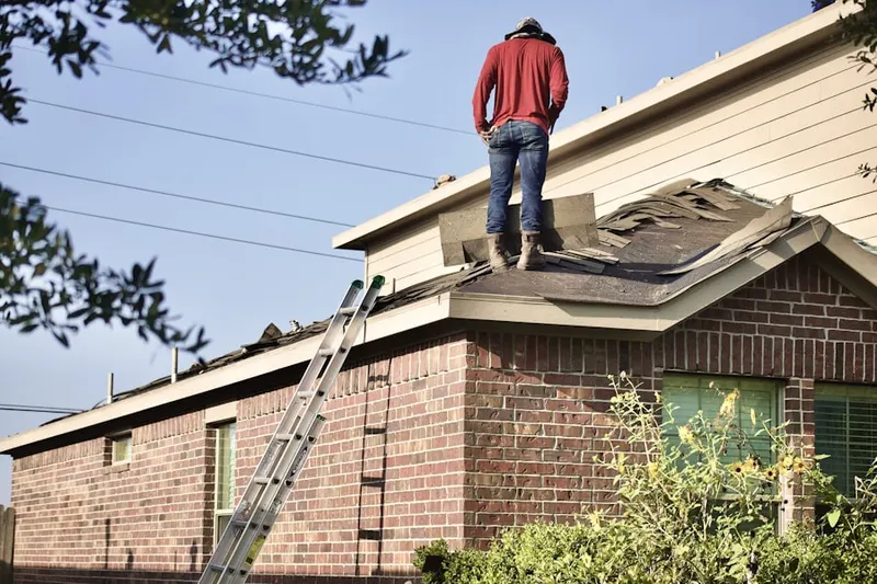 Professional roofer working on a residential roof in Bryan Place